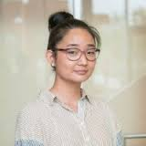 A professional portrait of a young woman in a business setting