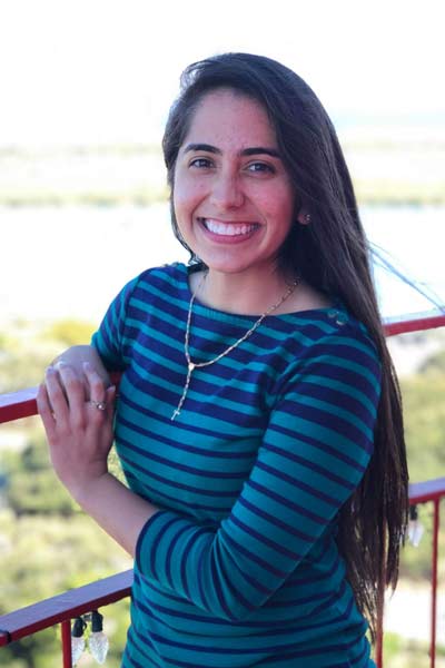 A young woman standing outside on a balcony