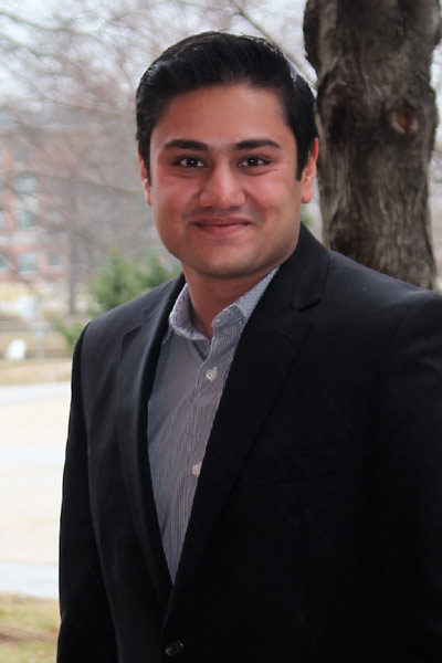 A young man standing next to a tree