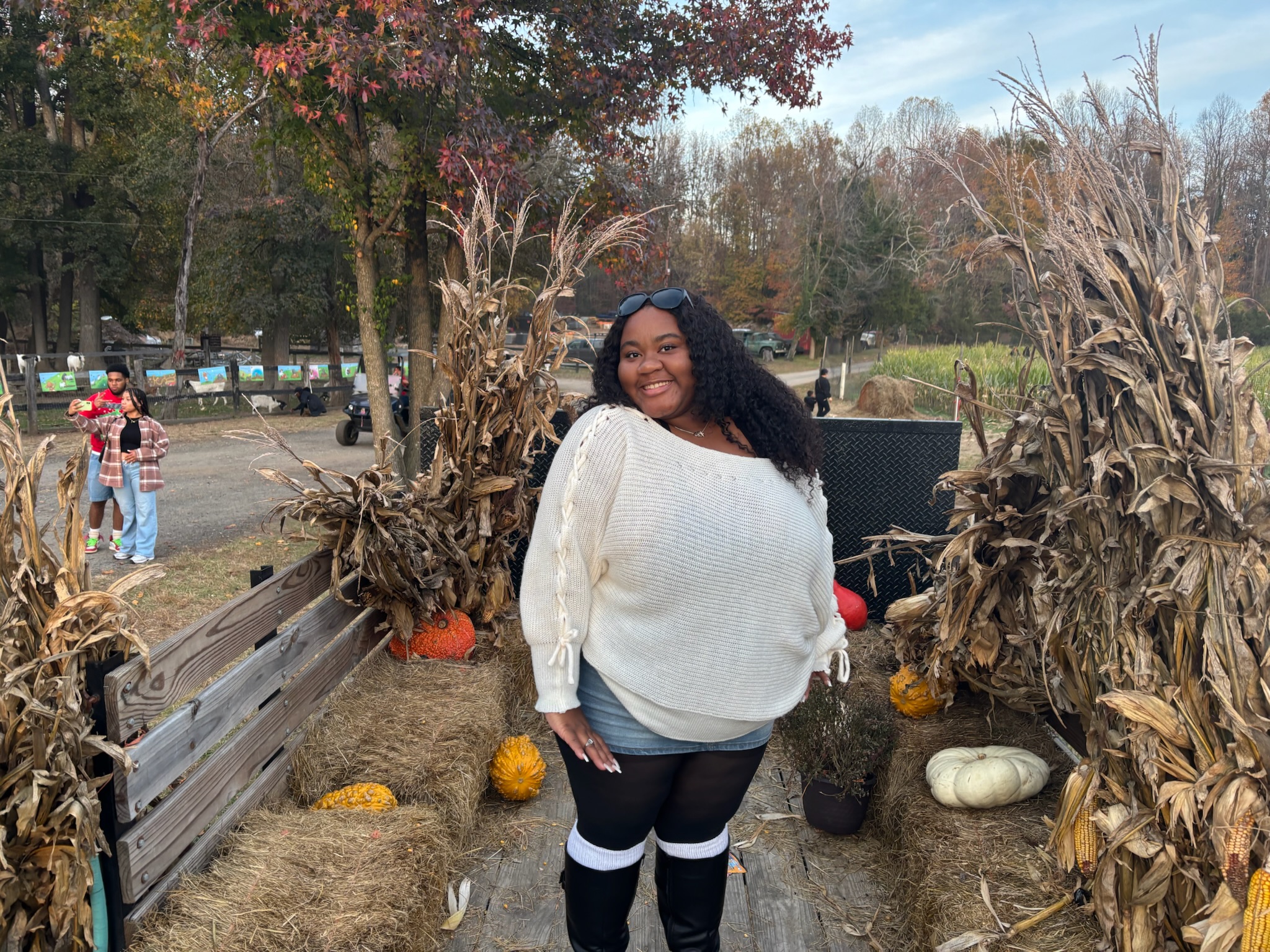 Kayla on a wagon with by pumpkins and hay