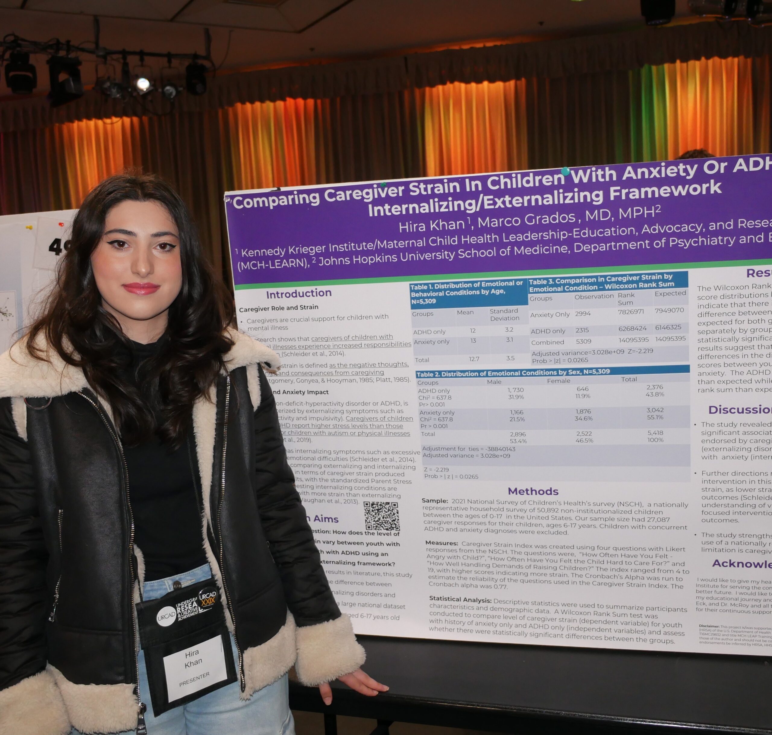 Hira smiling while standing with her URCAD presentation board 